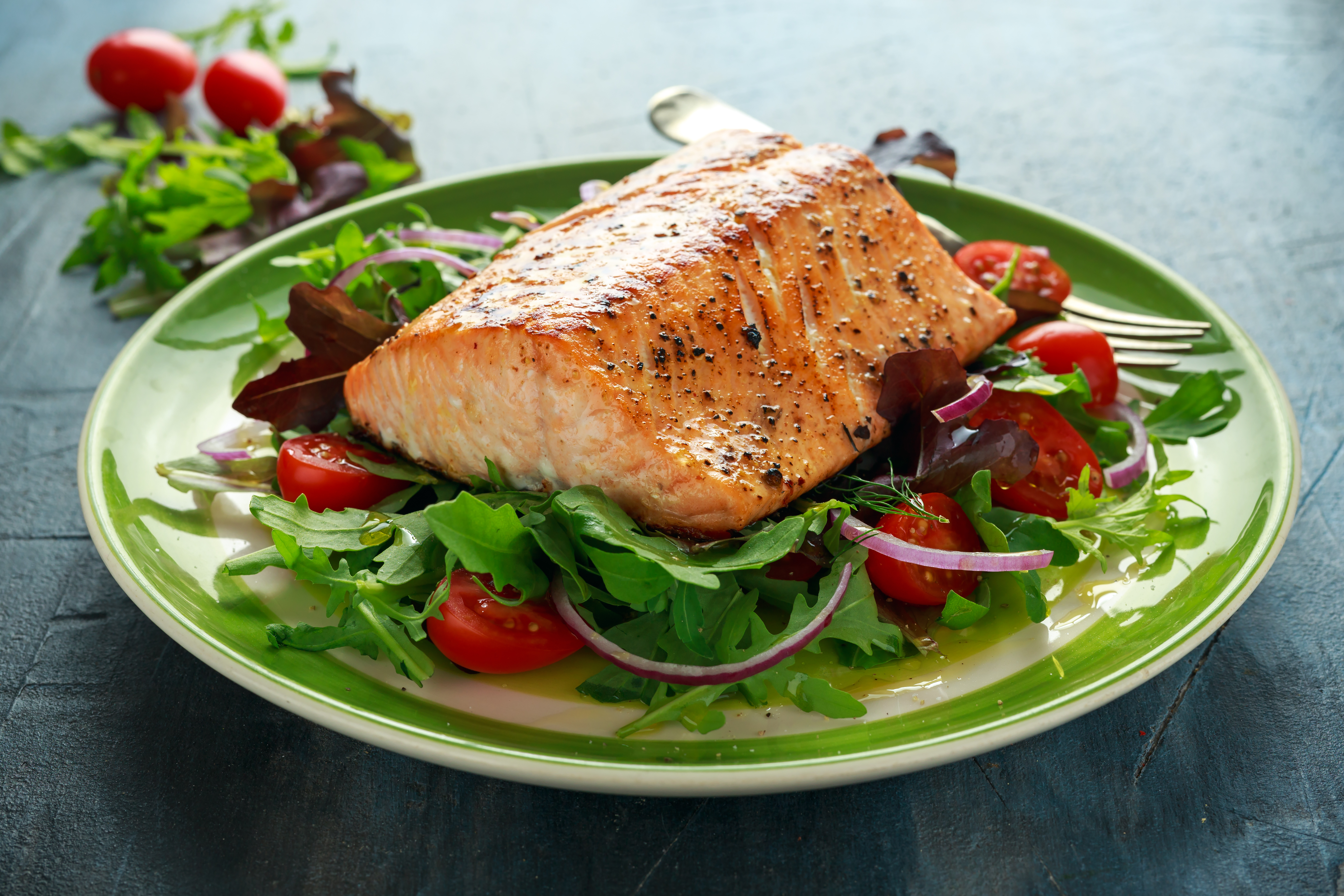 Salmon fillet on a plate of salad