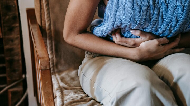 Person holding abdominal area with cramps