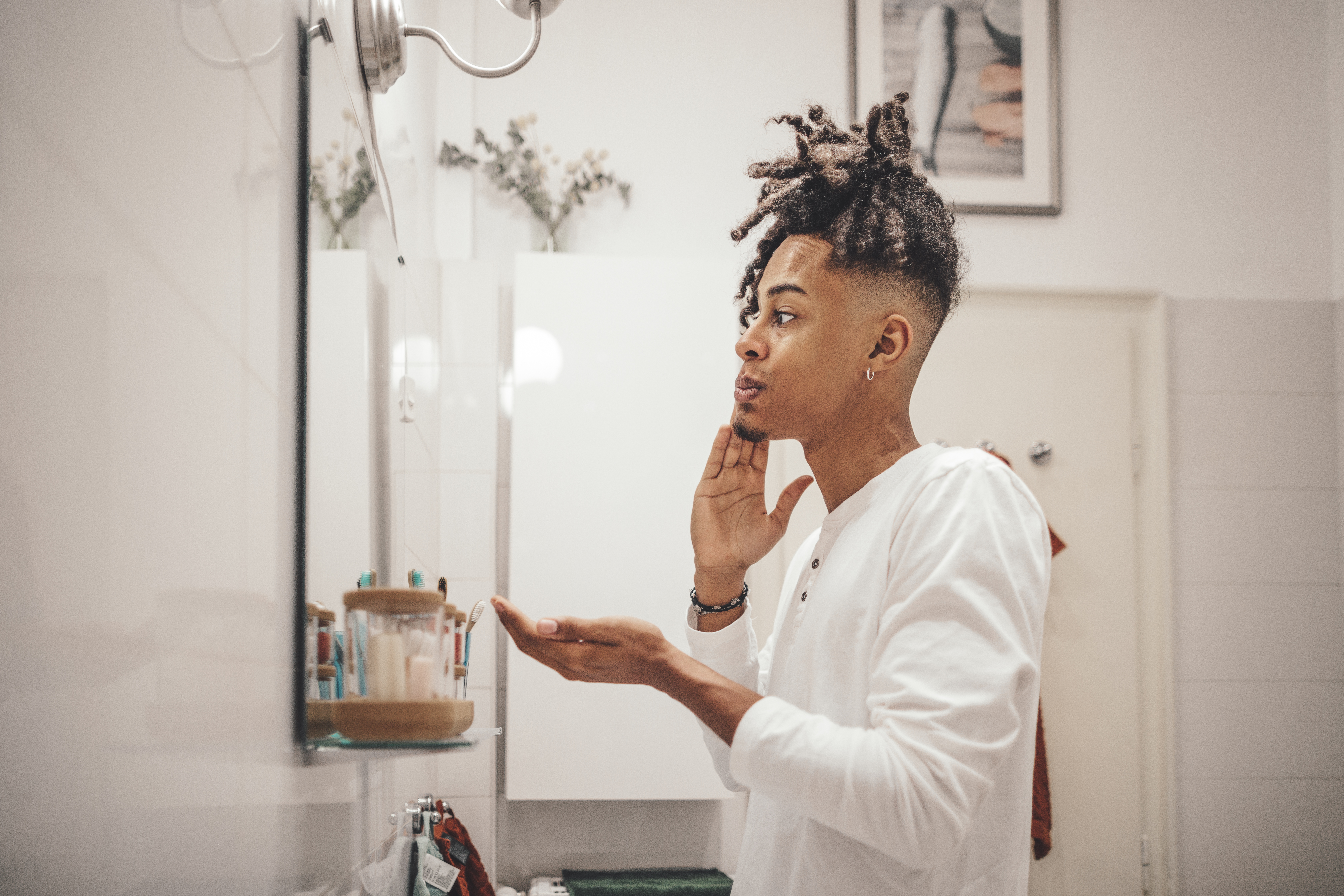 Young adult applying apple cider vinegar to their face