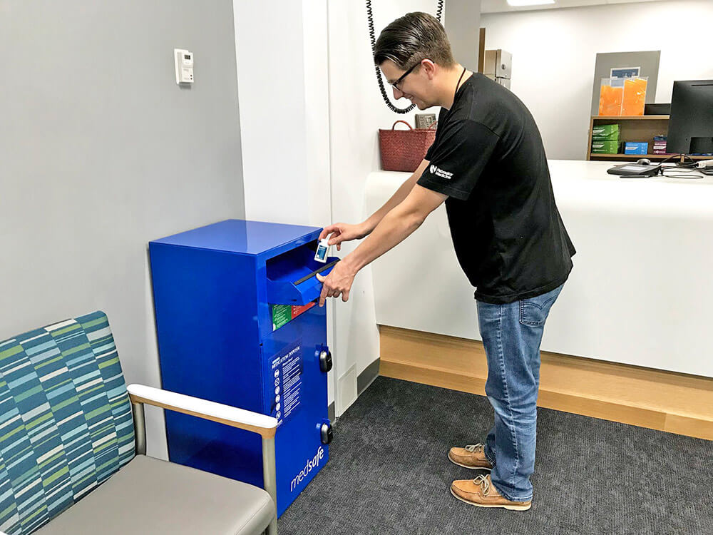 Person disposing of prescriptions in drop box