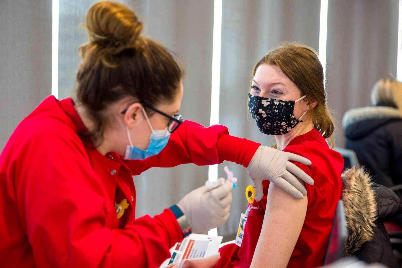 A UNMC student gives a fellow student a COVID-19 vaccine.